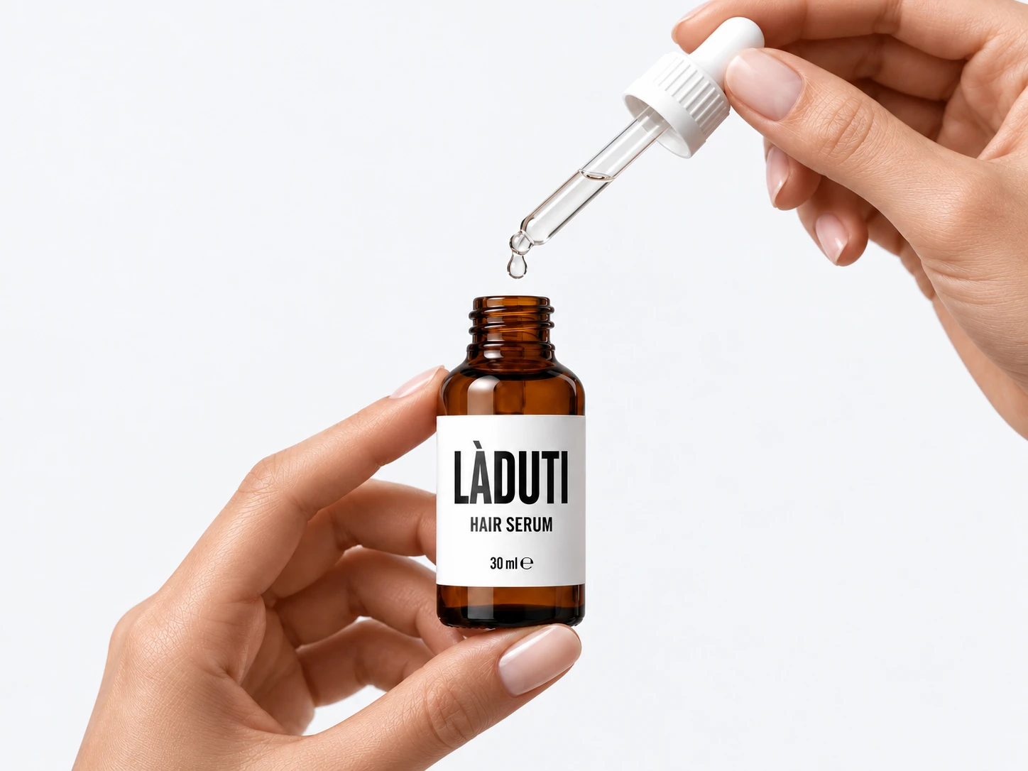 Eine Hand hält die Pipette über die geöffnete Flasche Laduti Hair Serum